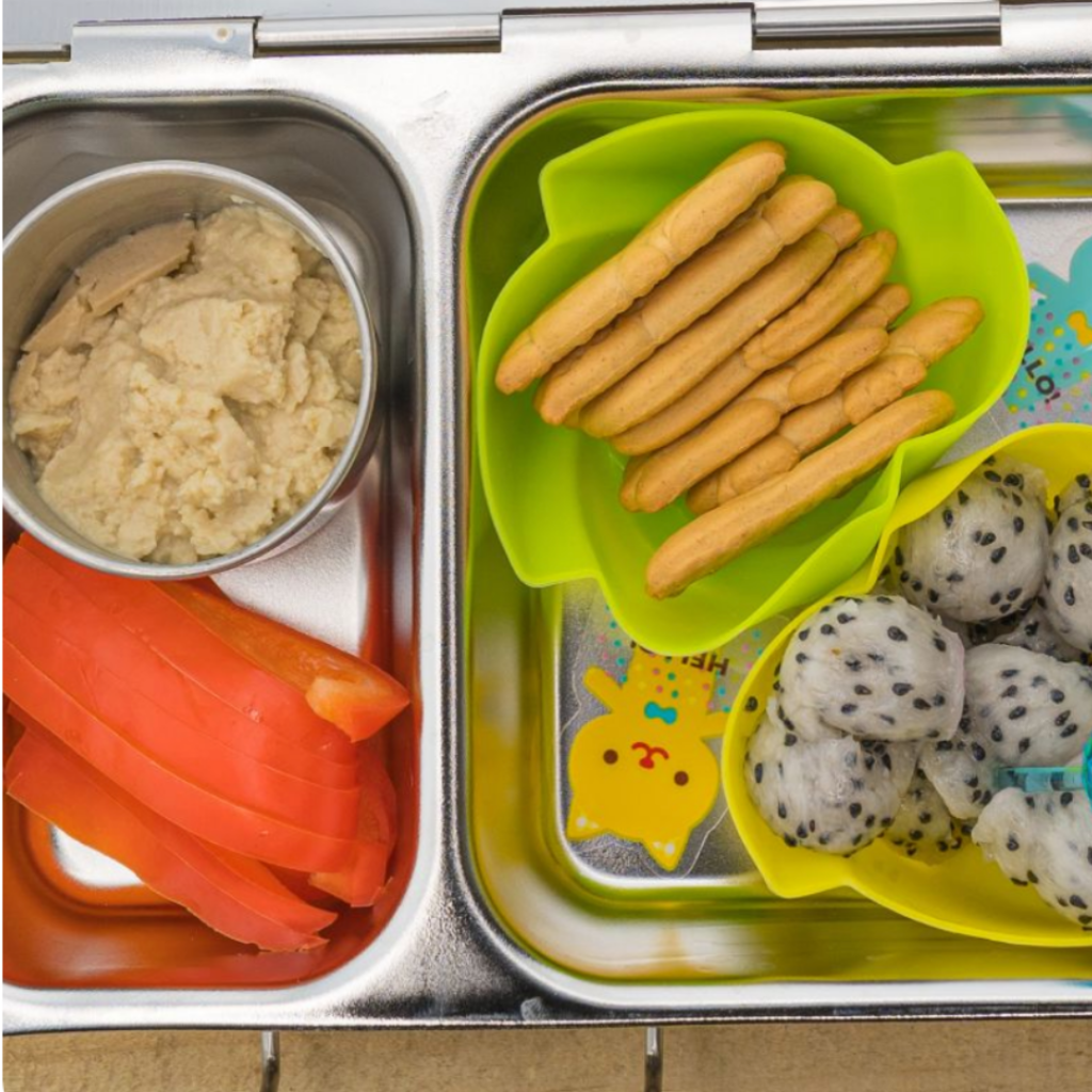Kids snack idea with hummus, bell peppers, cookies, and dragon fruit. Teuko lunchbox community.