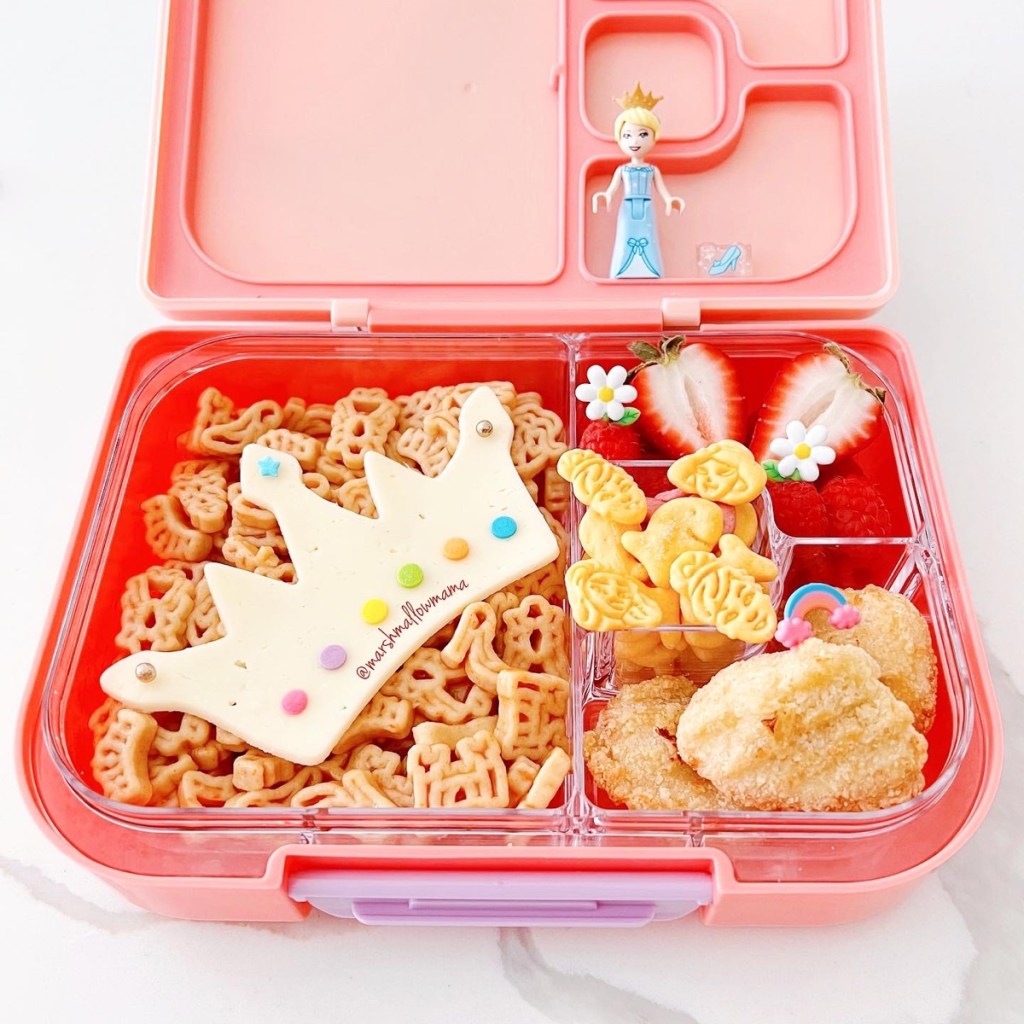 A cheesy crown on top of fairy tale-themed pasta, and a few chicken nuggets on the side. For dessert, strawberries, and Disney Princess cookies. Let's not forget the few flowers and rainbow food picks here and there. Teuko Lunchbox Bento Kids Food School Lunch Community.