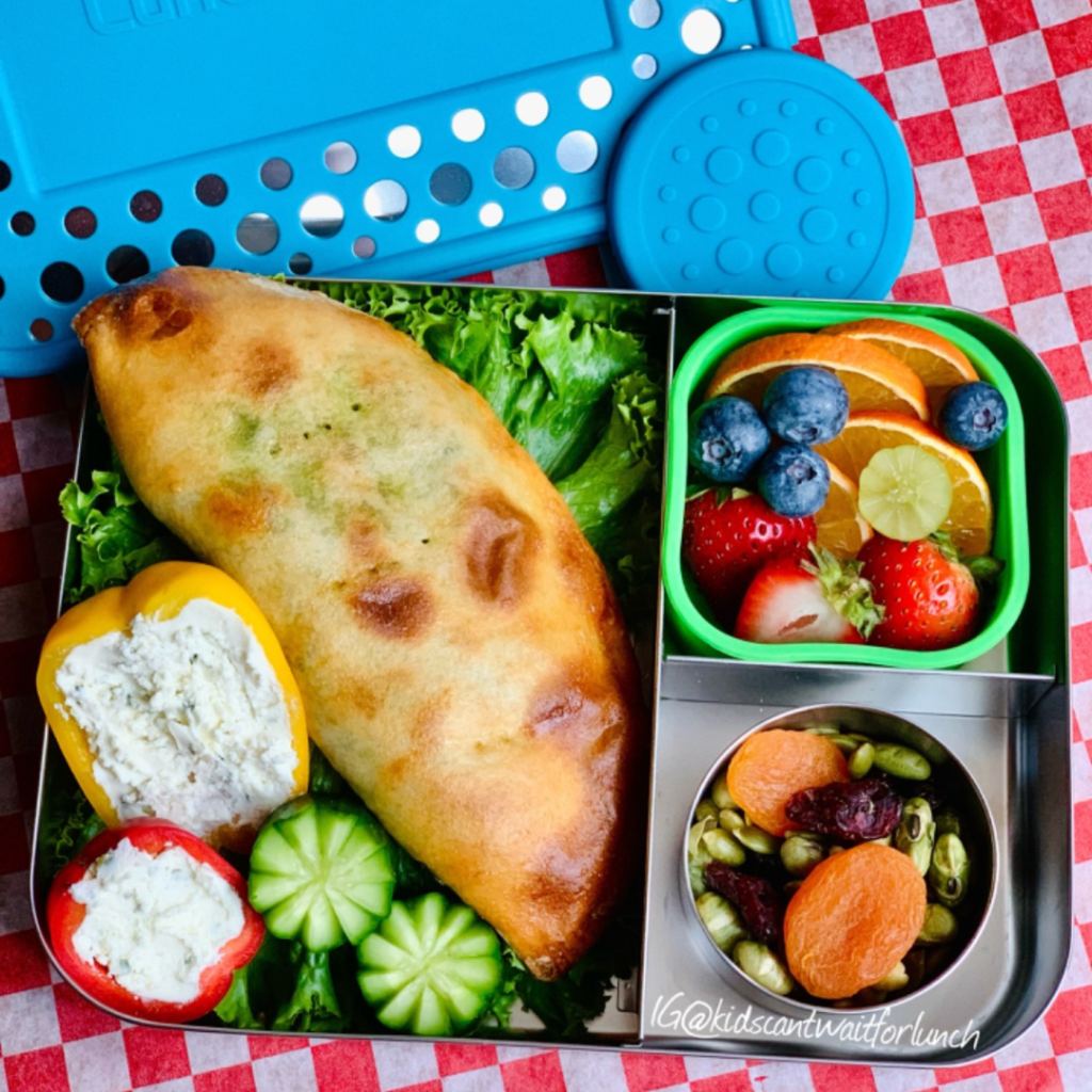 Teuko Lunchbox Community. on the right upper side of her LunchBots box, a fresh salad fruit, with orange slices, blueberries, strawberries, and a few green grapes. And, on the right bottom side of the box, a small container with an appetizing snack: a homemade trail mix with pumpkin seeds, dried apricots, and dried cranberries.