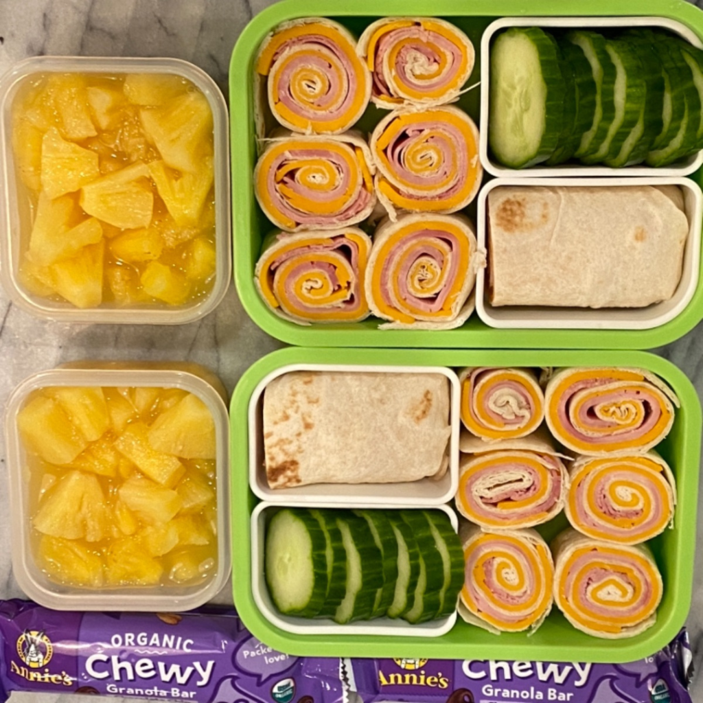 cheddar and ham tortilla rolls for kids' lunch in a bento lunchbox with annie's granola bar for snack