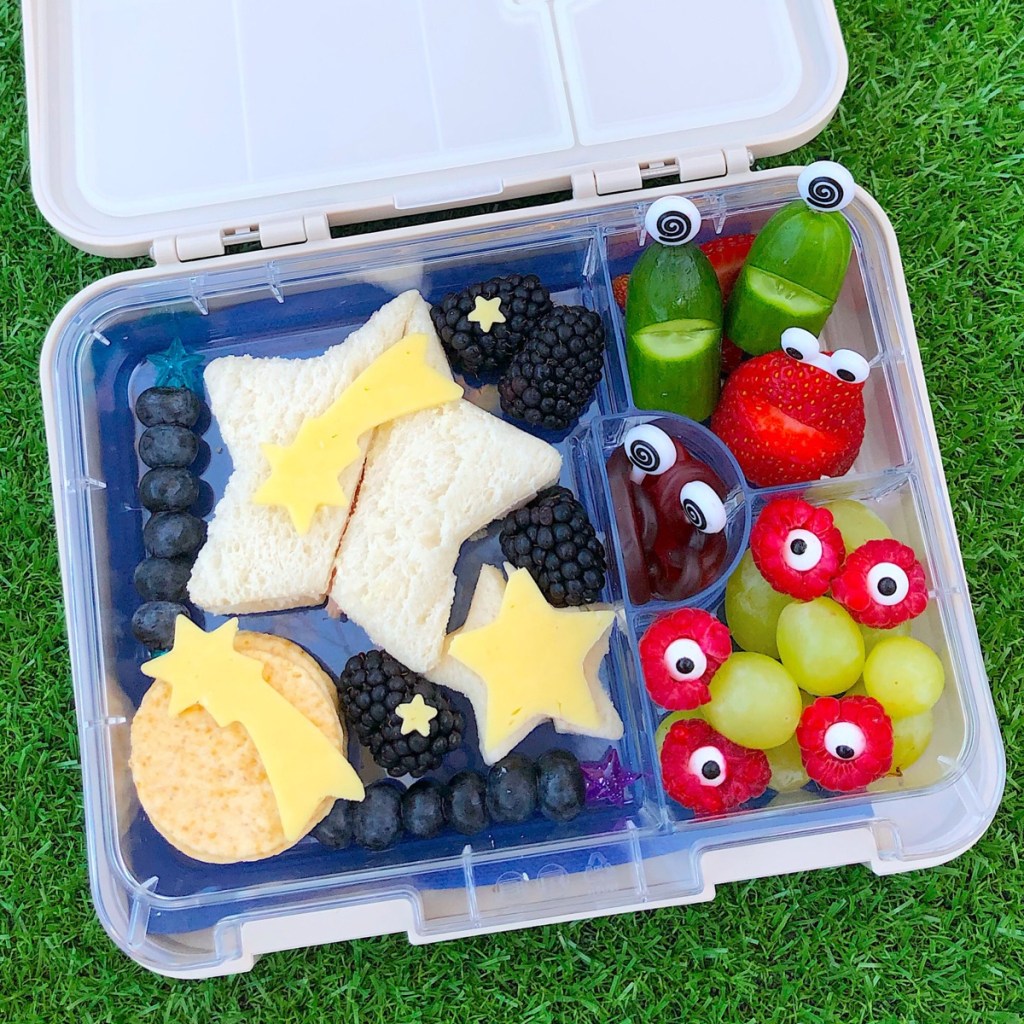 Space themed lunchbox for kids with star-shaped sandwiches and fruity aliens