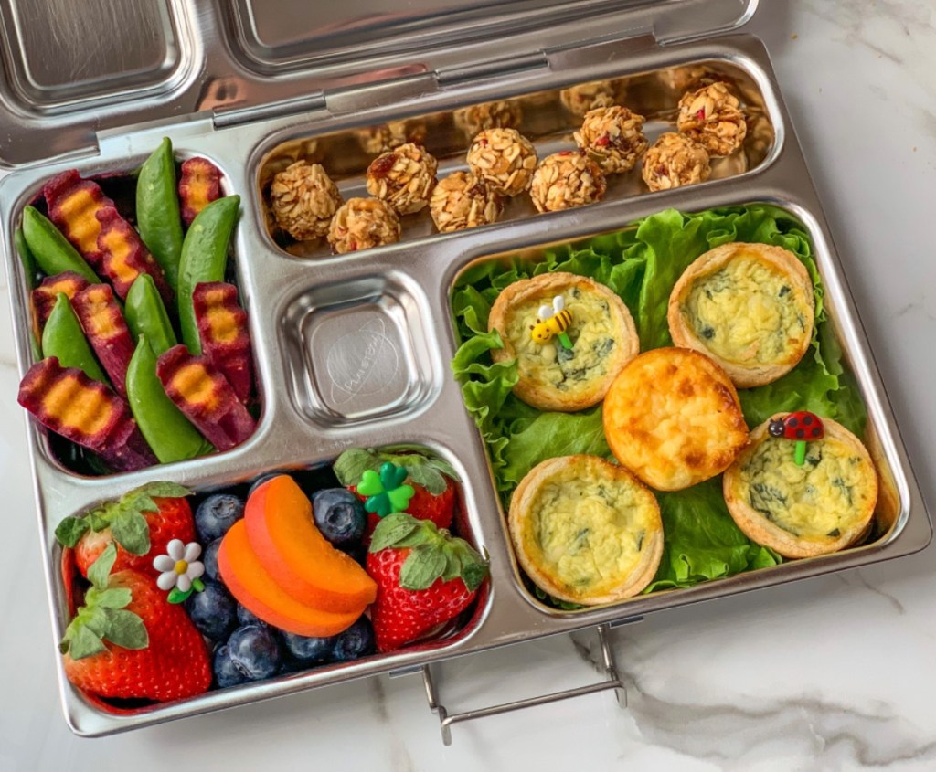 Colorful lunch for kid with mini quiche, fruits, veggies, in a Planetbox bento lunchbox
