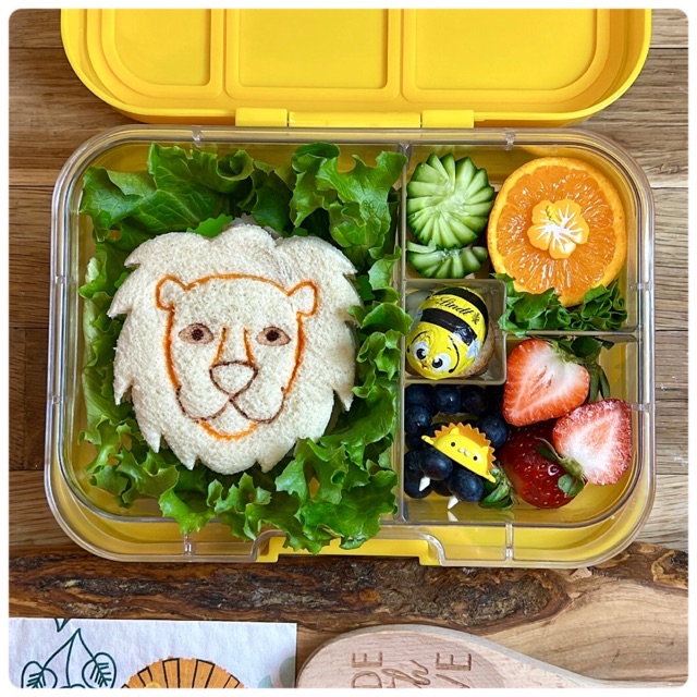 lion-shaped sandwich in a yellow lunchbox