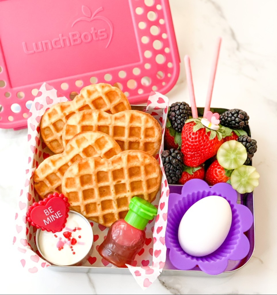 Greek yogurt and berries, hard boiled egg, and heart-shaped waffles for a Valentine's brunch-style snack box