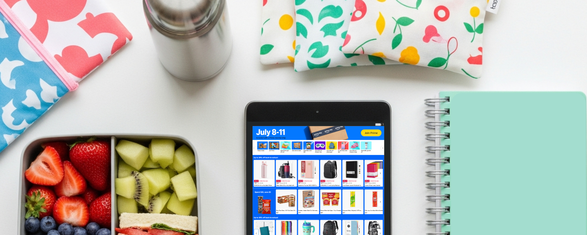 Colorful flat lay of school lunchbox, thermos, and school supplies styled for Amazon Prime Day Back-to-School shopping.