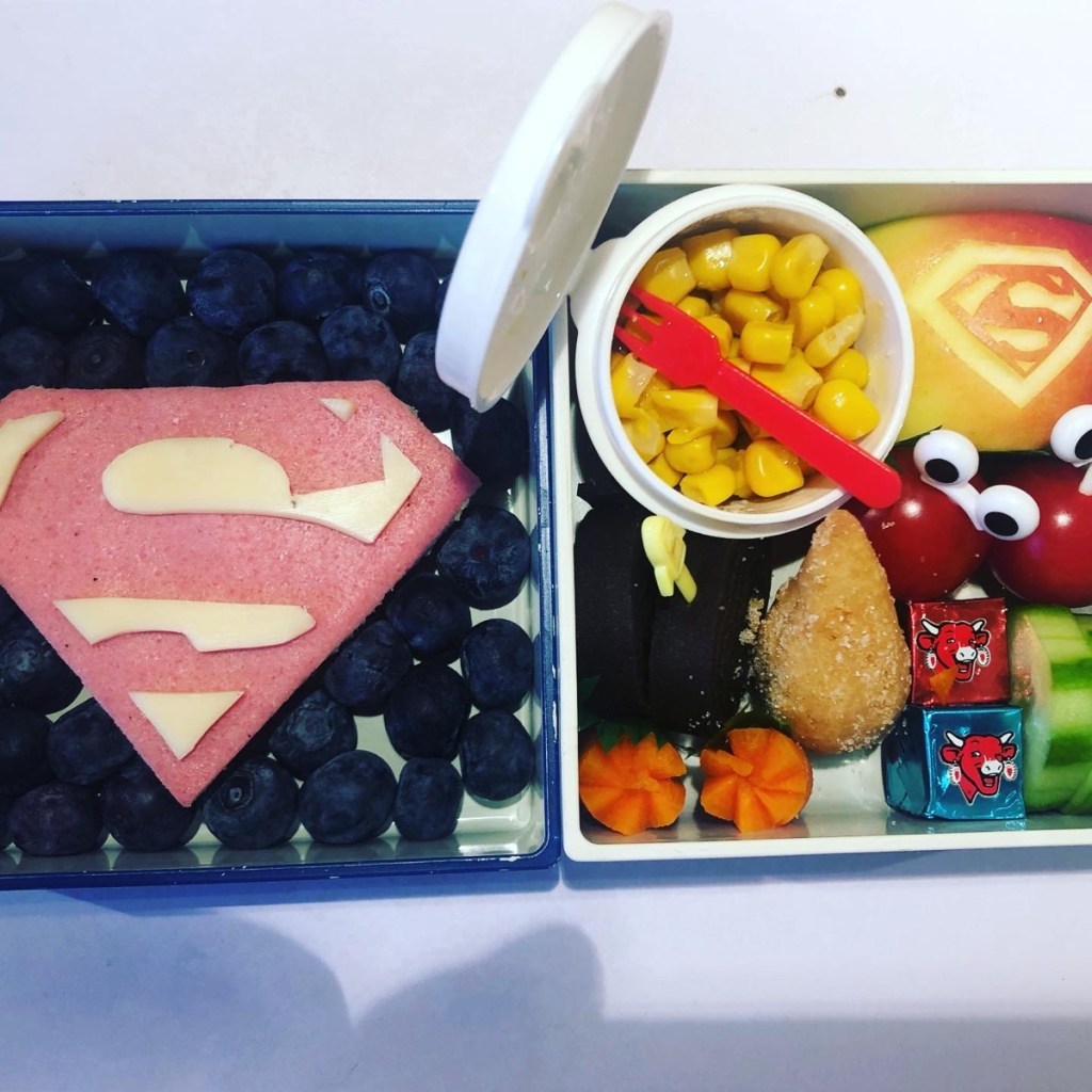 Salami and cheese Superman logo open sandwich in a Japanese-style bento lunchbox for kids.