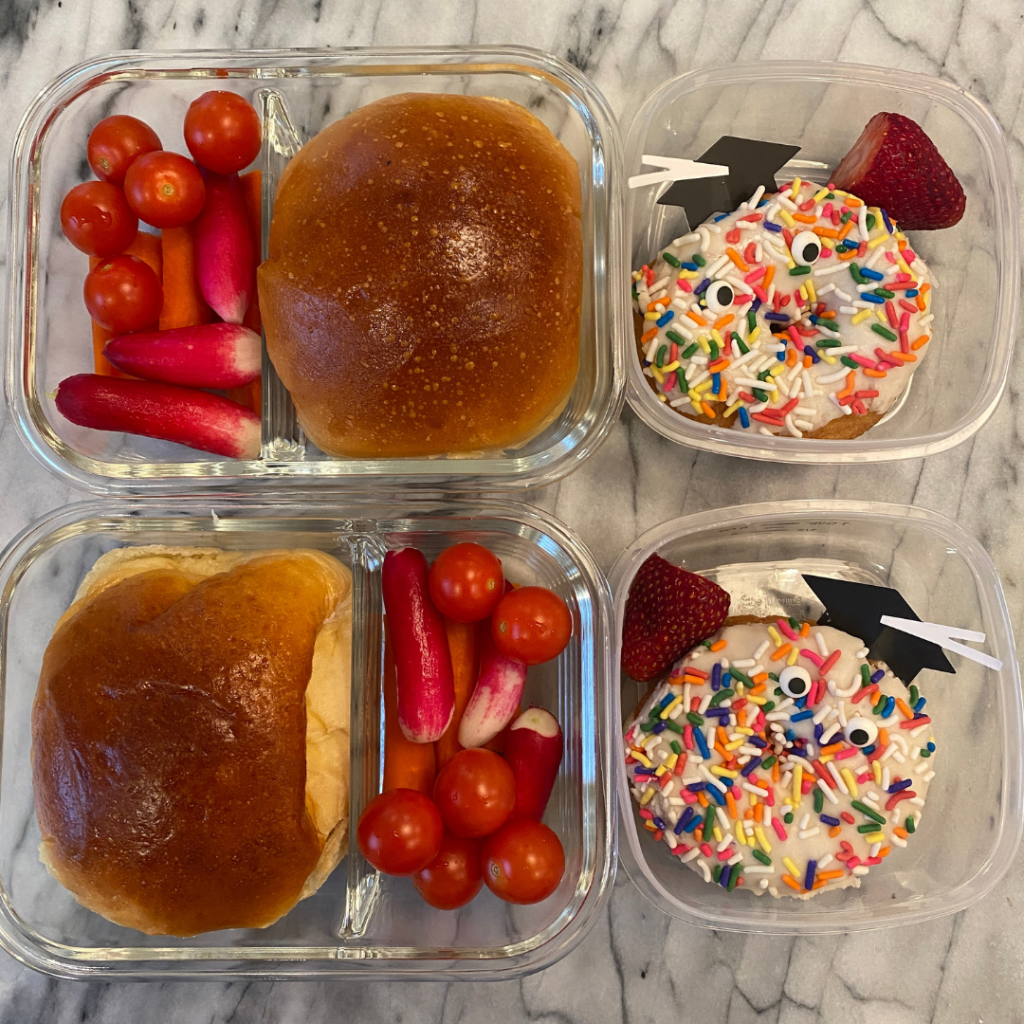 Festive school lunchbox featuring pulled pork slicers served as finger foods, with a celebratory donut for dessert, decorated with graduation-themed picks to mark the end of the school year - a fun and satisfying meal prep for kids and teens by Teuko.