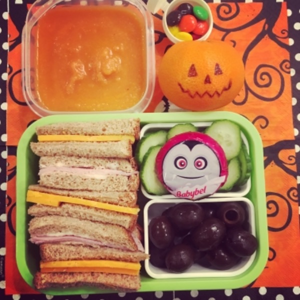 Tomato soup with bite-sized ham and cheese sandwiches, plus a Halloween-themed Babybel and a Jack O Lantern mandarin for a kid's lunchbox.