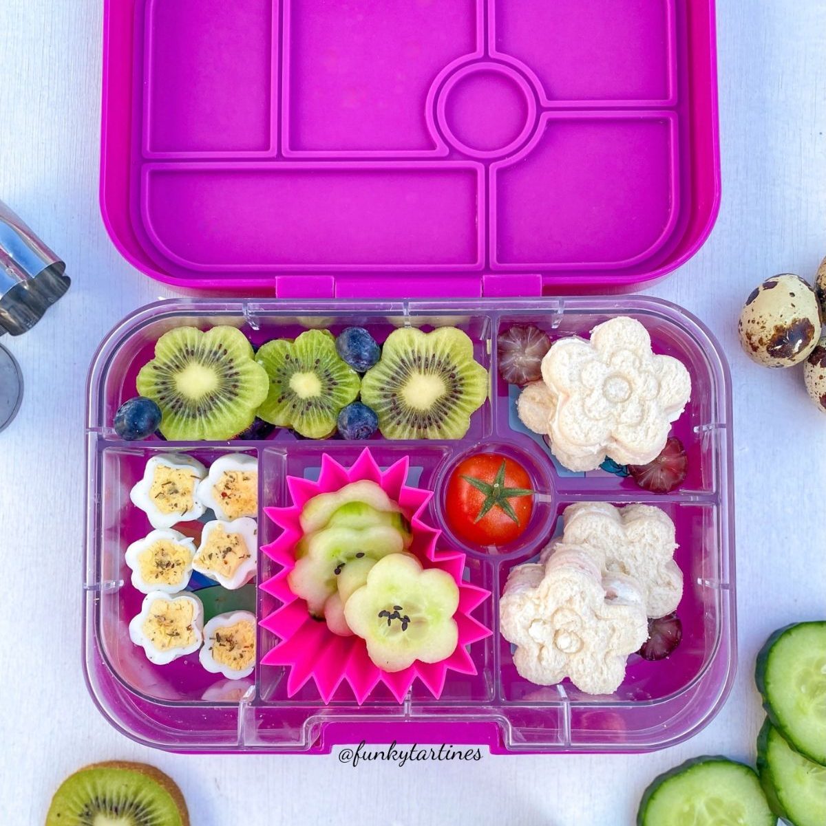 Spring themed lunchbox with kiwi flowers, cucumber flowers, hard boiled eggs flowers, and flower sandwiches.