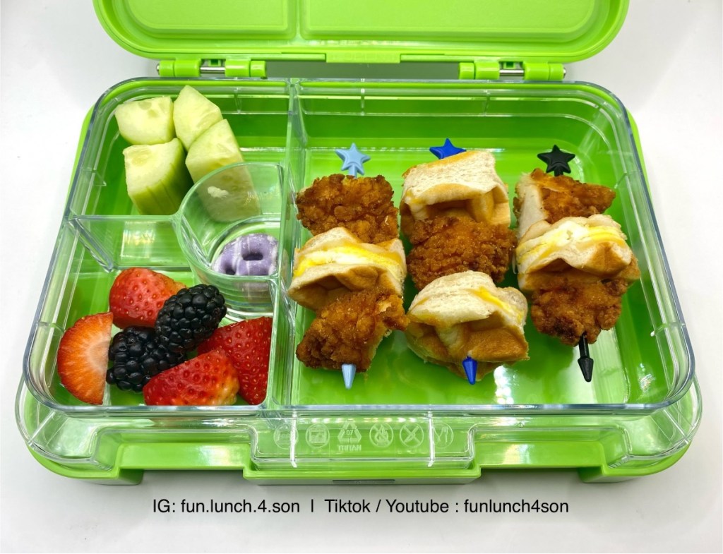 Skewers of fried chicken and biscuits in a kid's lunchbox